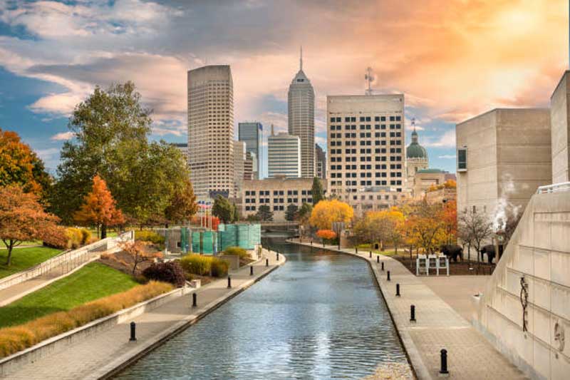 Canal urbano com passarelas e vegetação em Indianapolis.