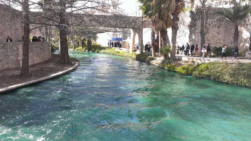 Caminho arborizado ao lado dos canais do River Walk.