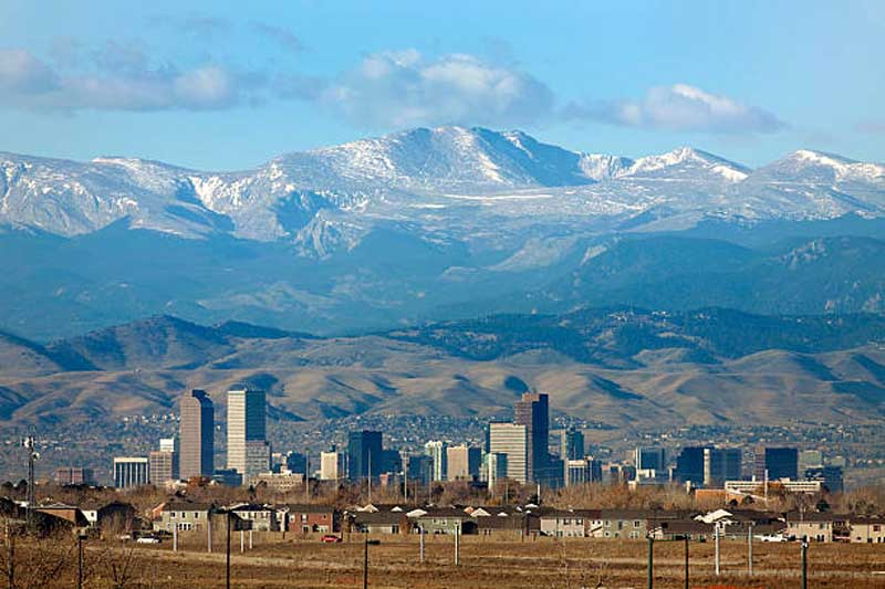 Vista panorâmica do centro de Denver com as Montanhas Rochosas ao fundo.